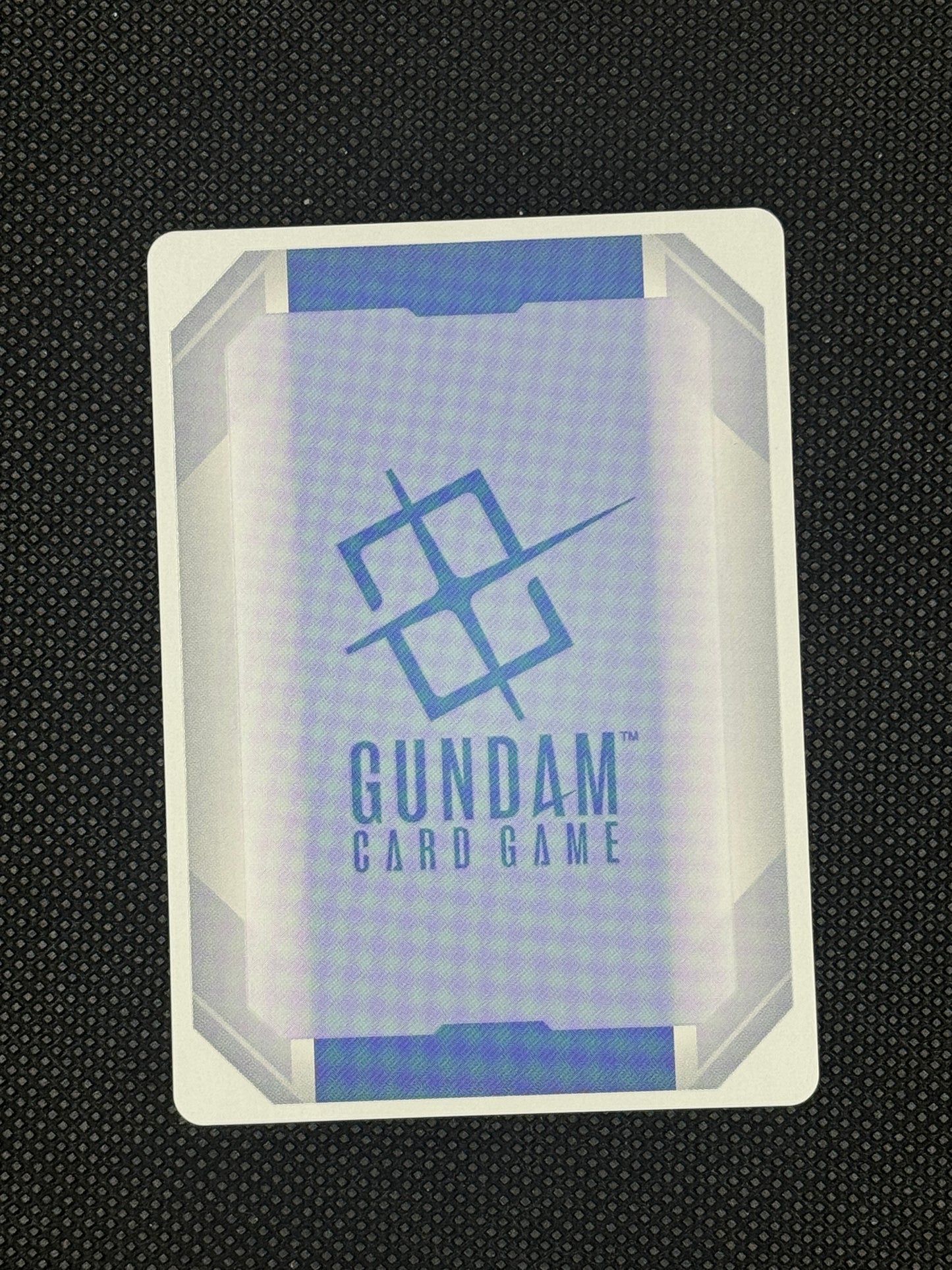 Gundam card game card with branding on a textured black background