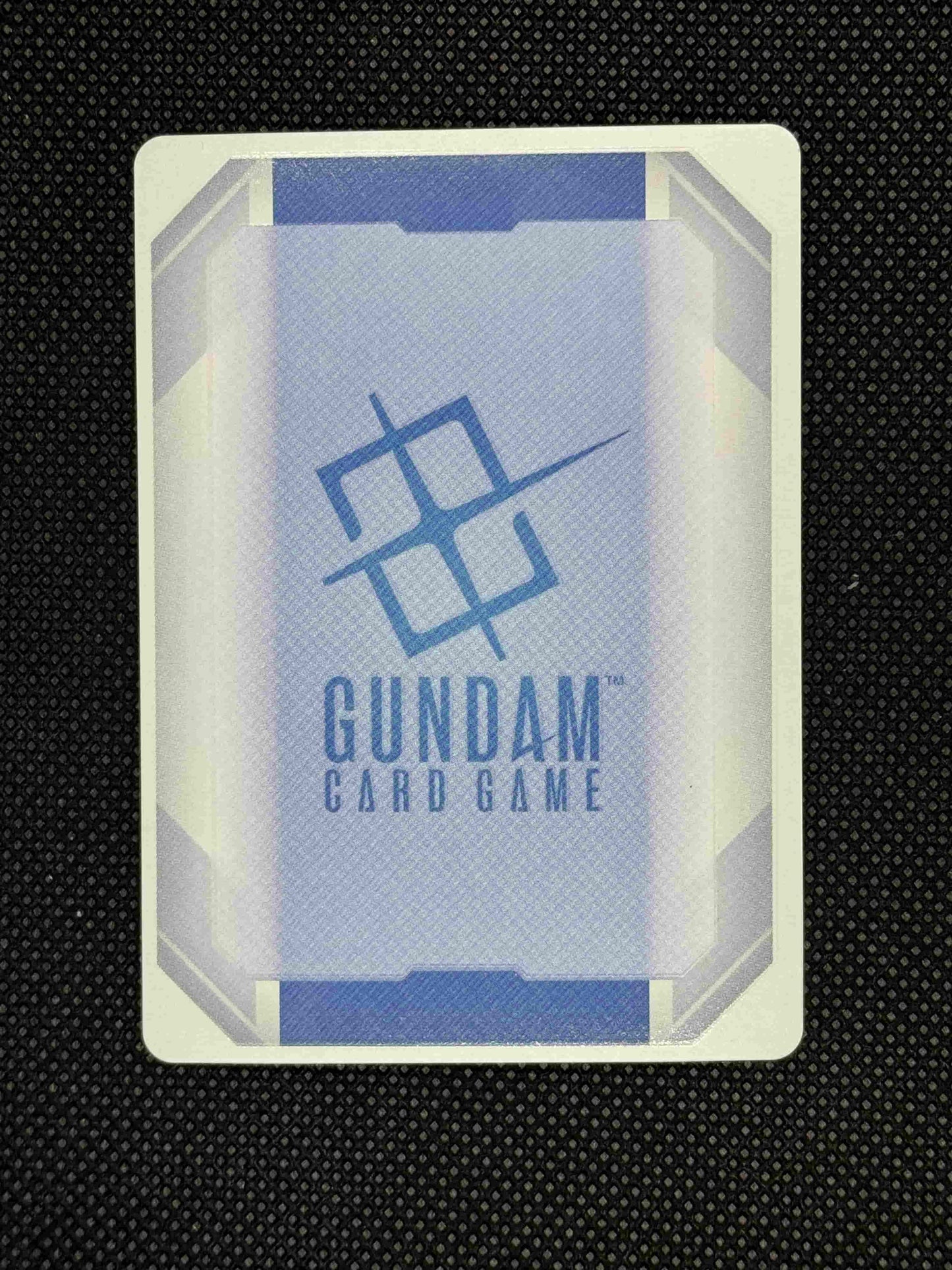 Gundam card game with visible branding on a black textured background