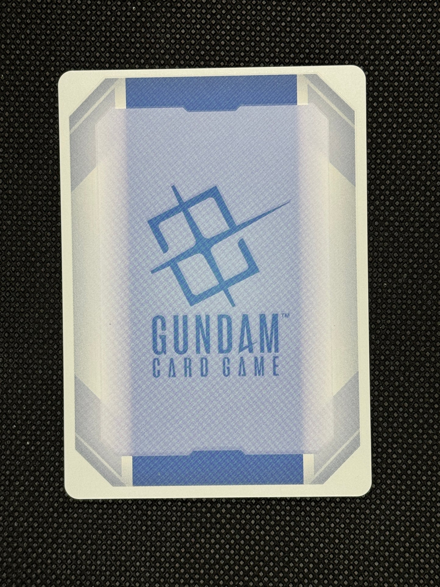 Gundam card game box on a textured black background