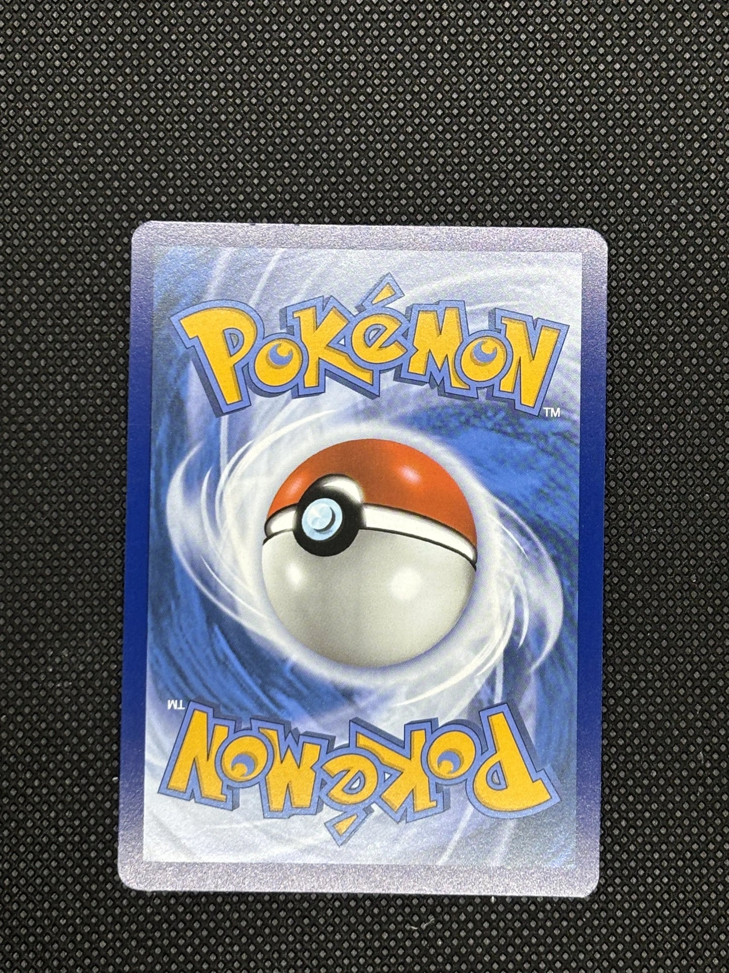 Backside of Teal Mask Ogerpon EX that has a Pokeball with a blue background.