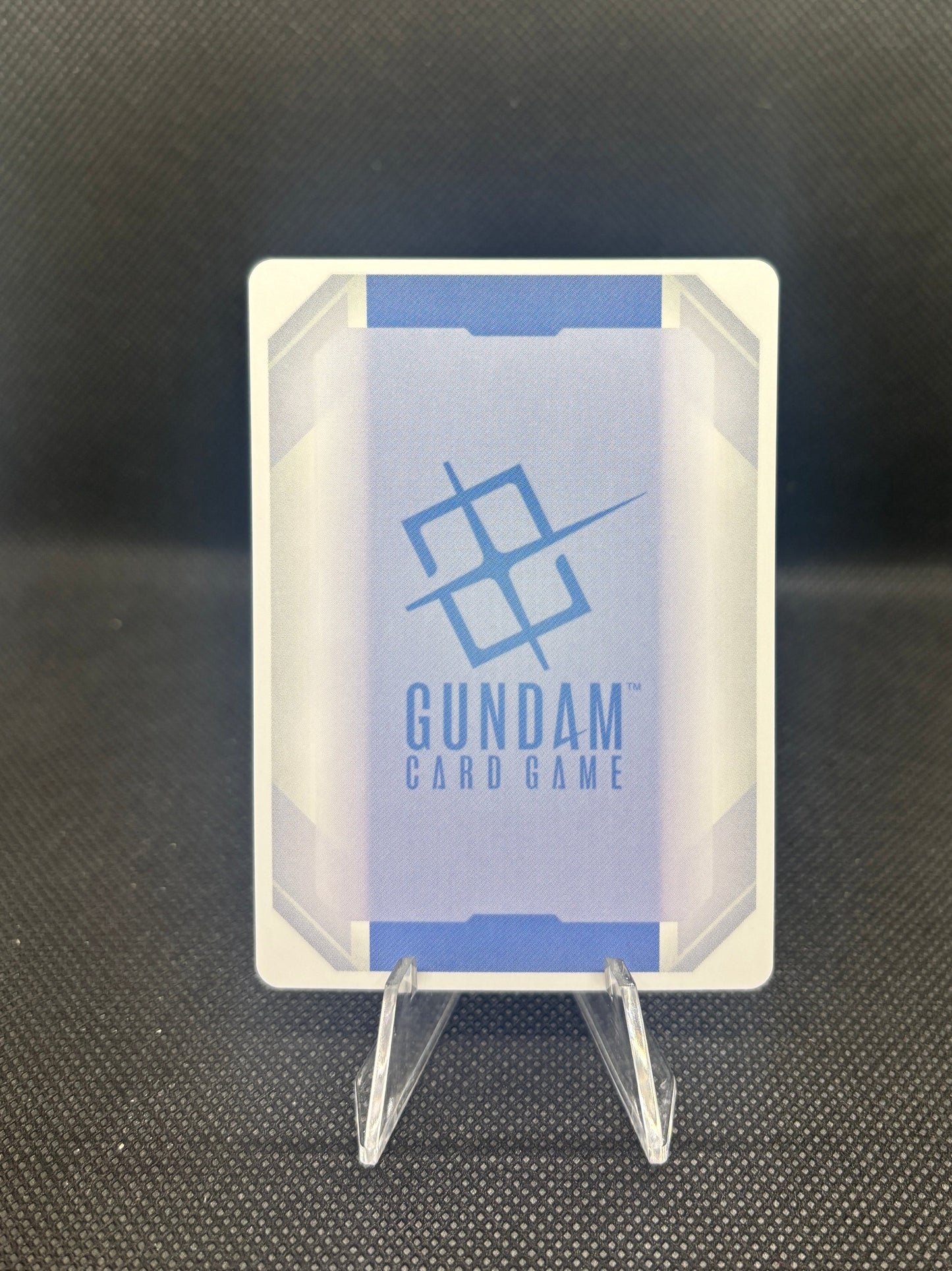 Small electronic component with 'Gundam' branding on a dark textured background