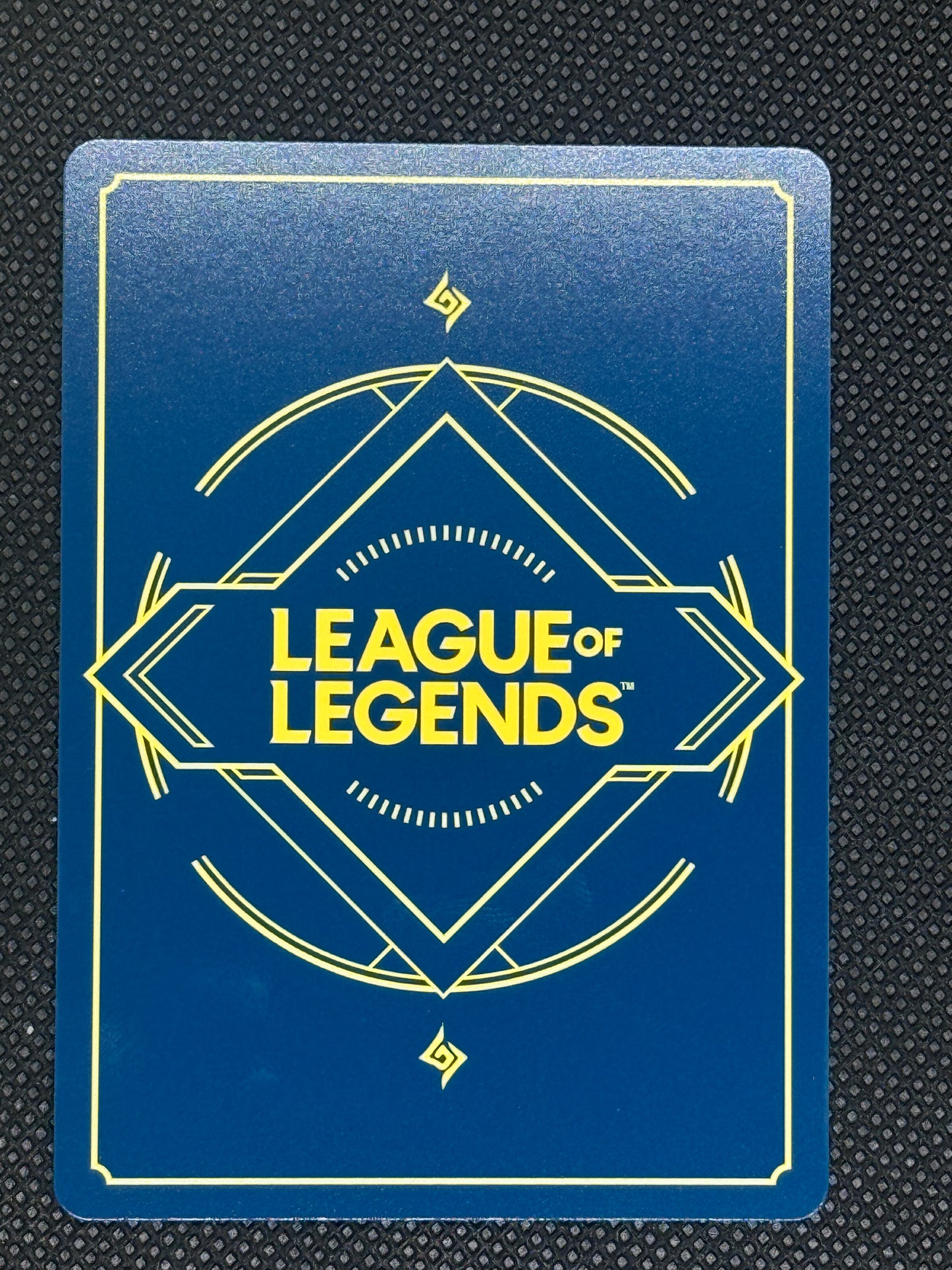 League of Legends card with blue background and yellow text on a textured black surface