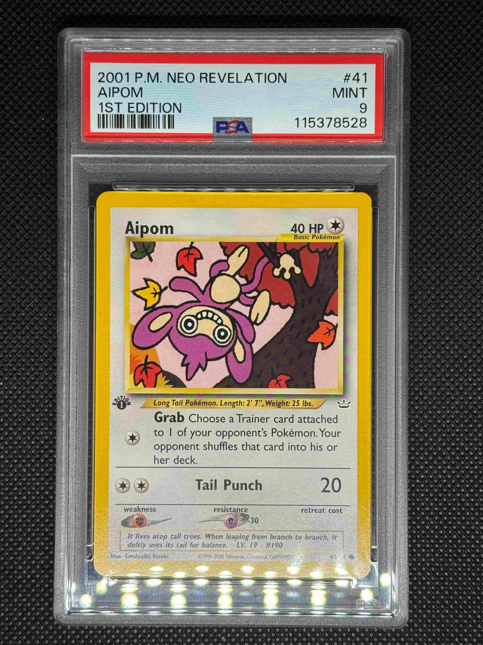 Aipom in a protective case with PSA grading label 9 with its ID number, card number, set, and barcode.