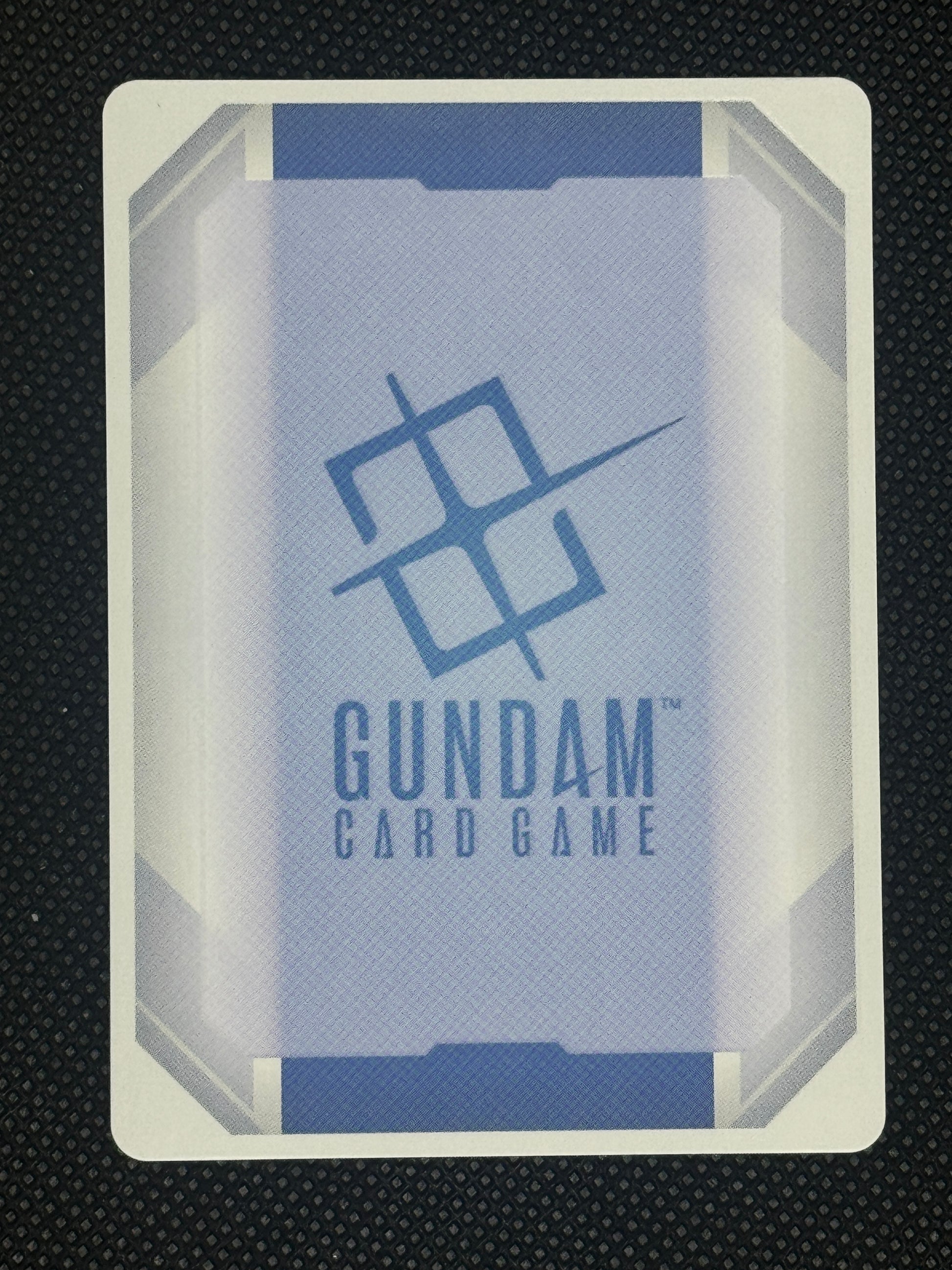 Gundam card game packaging with 'Gundam' branding on a textured black background