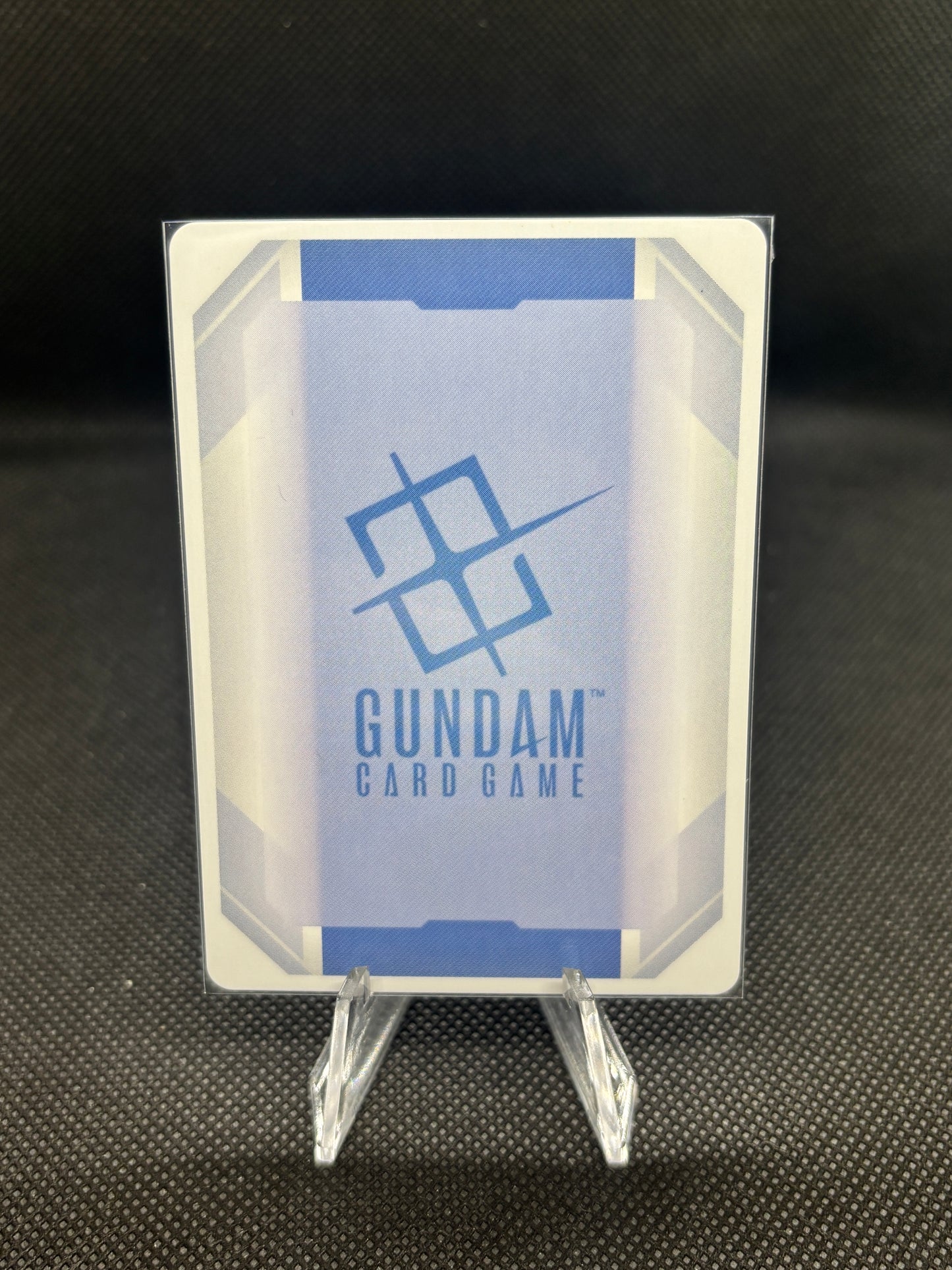 Gundam card game packaging on a dark textured background