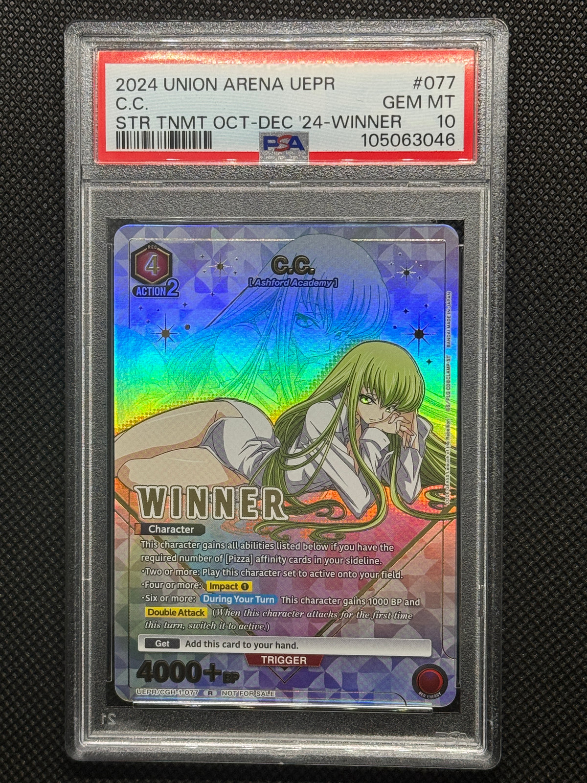 C.C. laying down looking straight at you with a silver background and winner text stamped on the card.