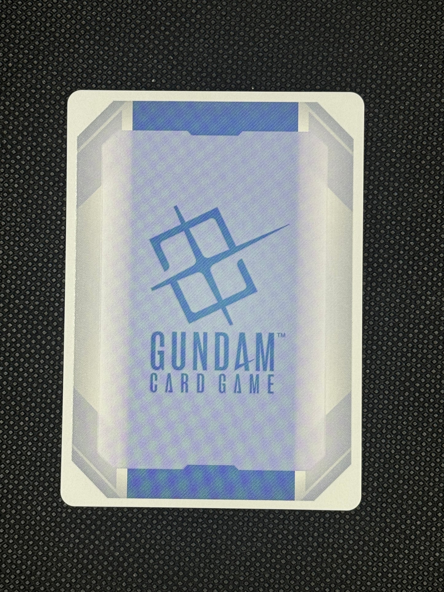 Gundam card game packaging on a textured black background