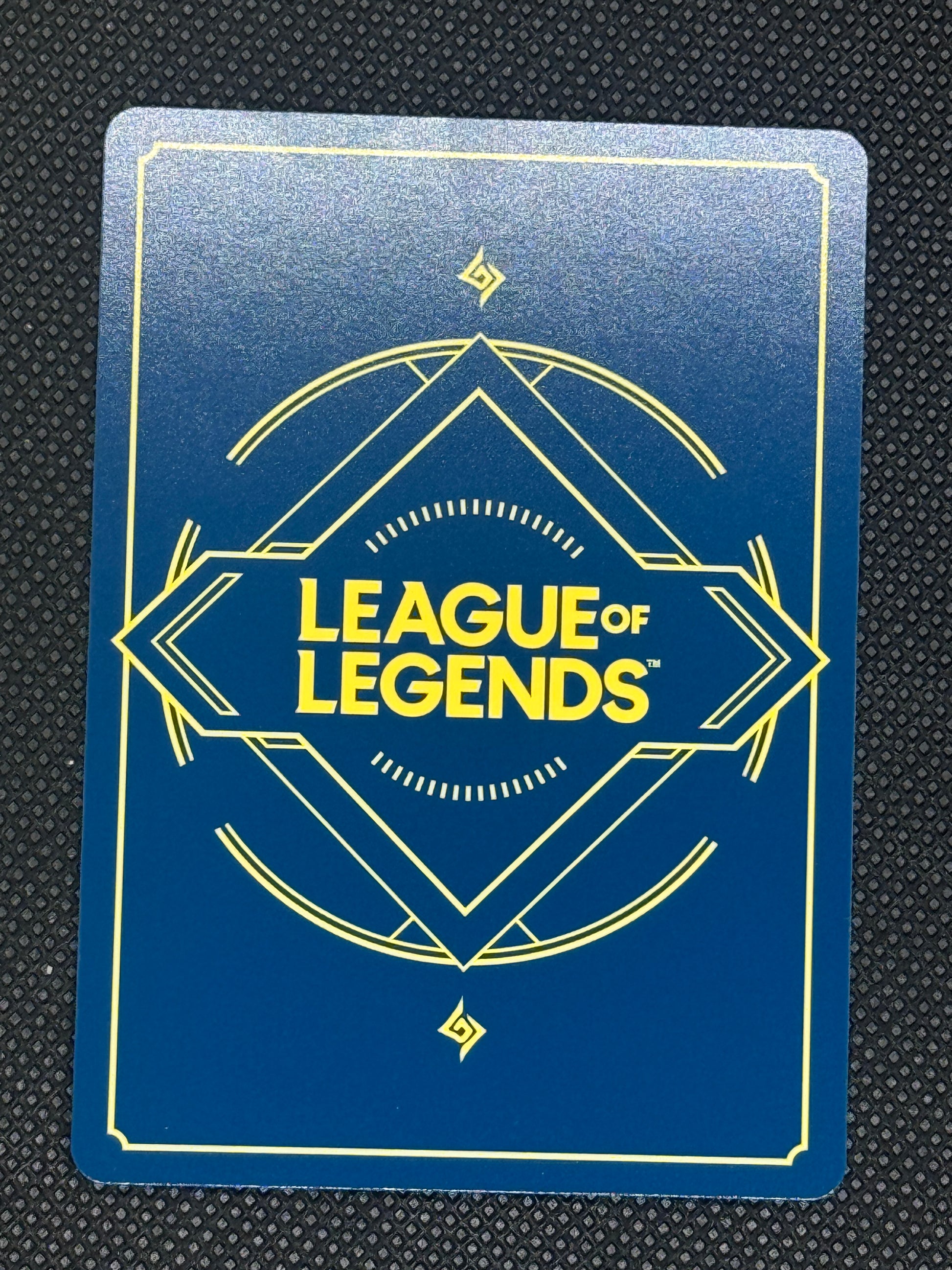 League of Legends card with blue background and yellow text on a textured black surface