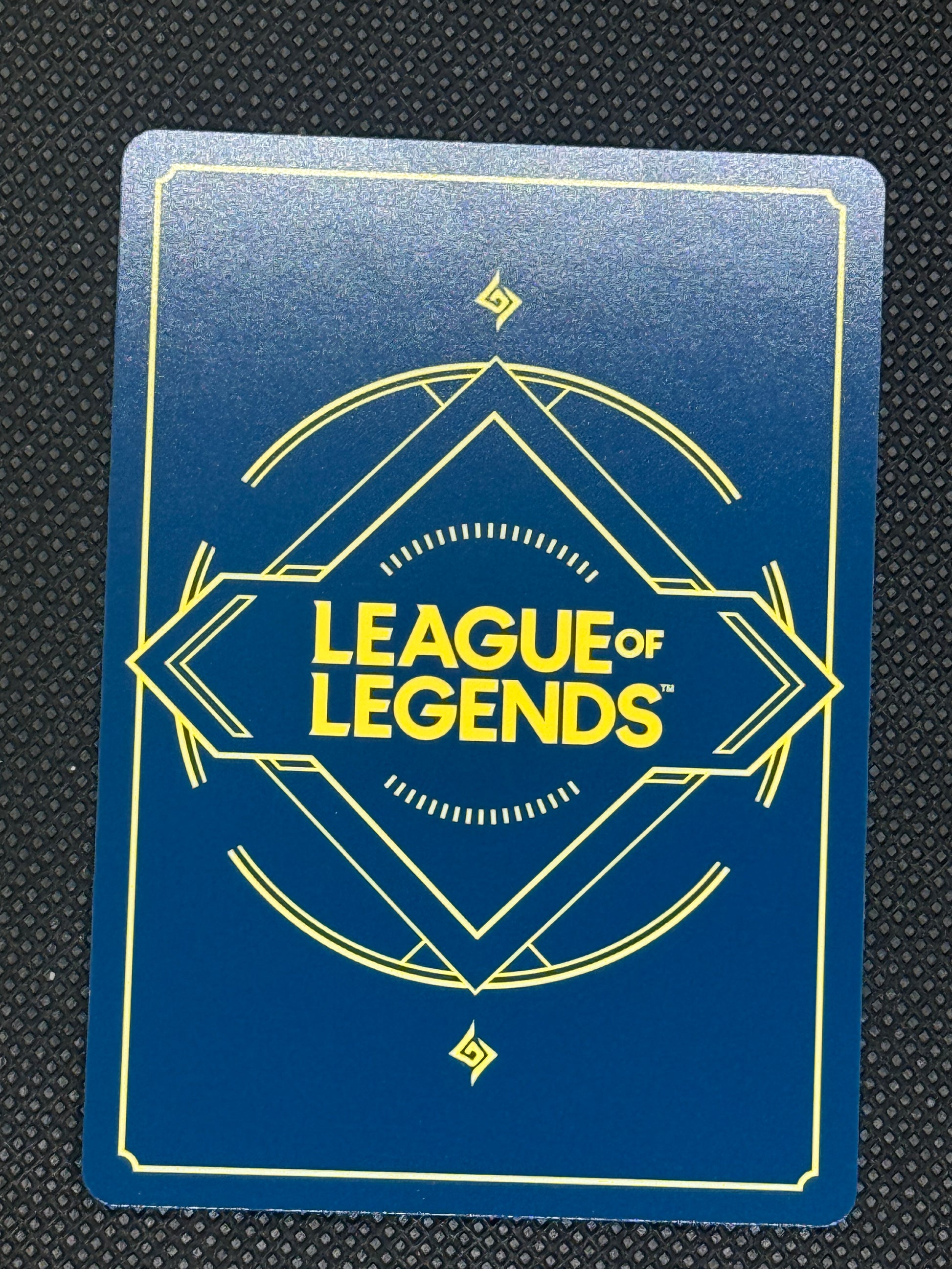 League of Legends card with blue background and yellow text on a textured black surface
