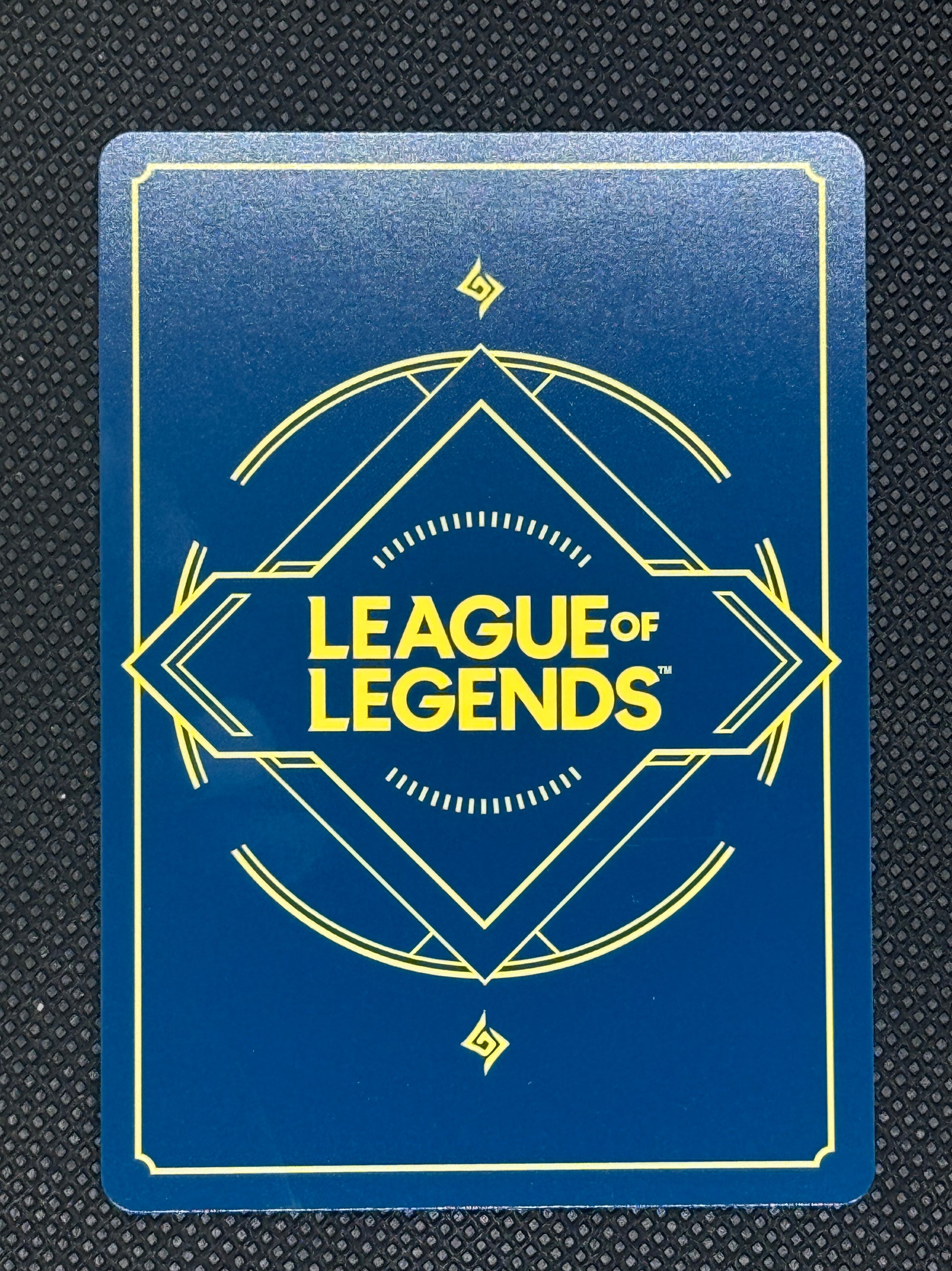League of Legends card with blue background and yellow text on a textured black surface